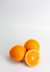 whole oranges and half an orange on a white background