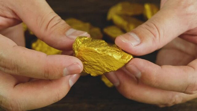 The man's hand was holding the gold ore found in the mines
