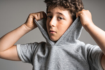 portrait of young and cute teenager with hoodies on studio grey