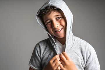 portrait of young and cute teenager with hoodies on studio grey