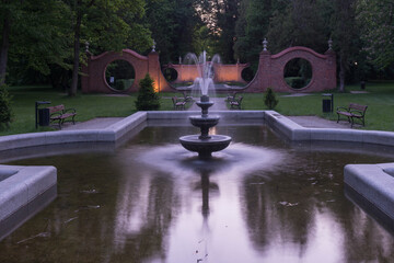 Fototapeta Park Dworski w Iłowej. Bramy księżycowe i parkowe fontanny w nocnej scenerii obraz