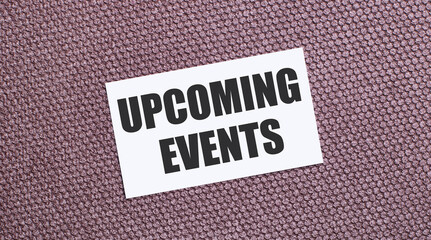 On a brown background, a white rectangular card with the text UPCOMING EVENTS