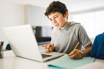 Pretty teen boy enjoys learning and doing some homework