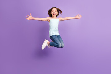 Full body photo of attractive crazy happy small girl jump up air enjoy free time isolated on purple color background