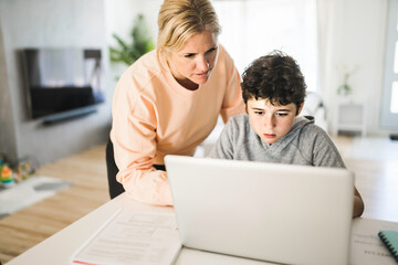 Mom helping kid with homework at home