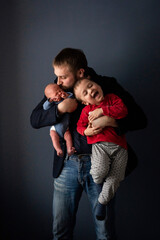 small baby crying, newborn baby, baby with dad and big brother, on blue isolated background, selective focus