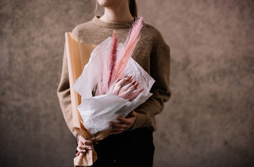 Very nice young woman holding big and beautiful flower bouquet with fresh flowers in colors 