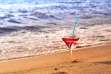 Wine glass with a cocktail by the sea.