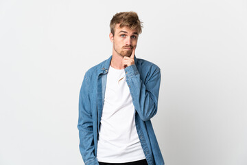 Young handsome man isolated on white background and thinking