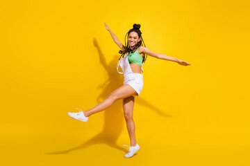 Full length photo of afro american young cheerful woman raise hands wings isolated on yellow color background