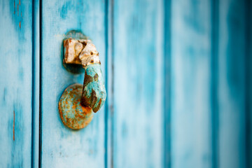 Weathered knocker on blue wooden door in Algarve, Portuga