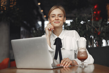 Businesswoman sitting at the table with a laptop