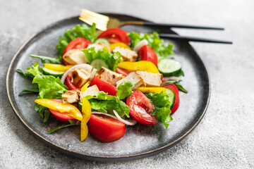 fresh chicken salad and vegetables tomato, cucumber, pepper organic wholesome dish on the table healthy food meal snack copy space food background rustic. top view keto or paleo diet veggie