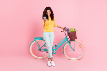 Full length body size view of pretty cheerful girl with bike using device blogging chatting...