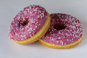 Tasty glazed raspberry donut with topping.