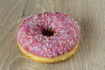 Tasty glazed raspberry donut with topping.