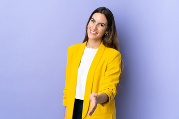 Young caucasian woman over isolated background shaking hands for closing a good deal