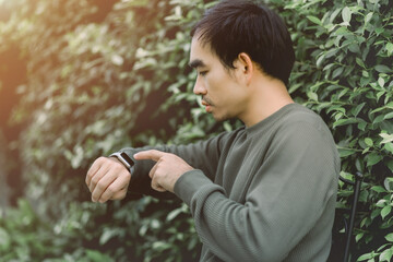 Portrait men watching time on his smartwatch outdoors.