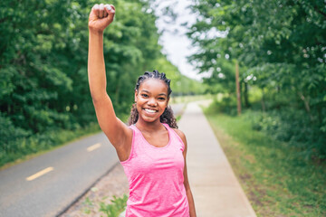 Woman runner in action outside in tree background