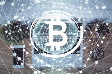 Blockchain theme hologram drawings over computer on the desktop background. Top view. Multi exposure. Concept of cryptoeconomy.