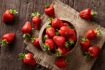 Fresh strawberries in bowl on wooden planks