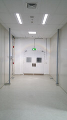 Emergency exit door way with green exit light sign, clean area, walk path way in the GMP factory