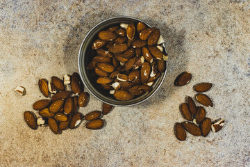 Almonds in rustic bowl on gray background