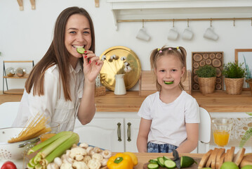 Healthy food at home. A cheerful mother laughs, has fun and hugs her daughter