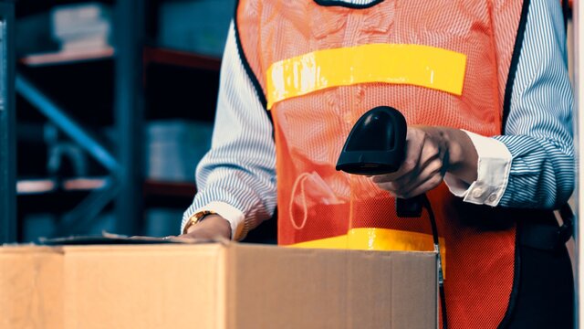 Warehouse worker using barcode scanner in storehouse . Logistics , supply chain and warehouse business concept .