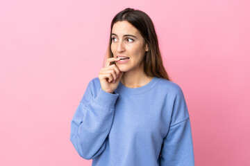 Young caucasian woman isolated on pink background nervous and scared