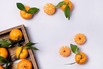 Fresh Ripe Tangerines on Wooden Tray With Leaves Light Blue Background Top View Horizontal