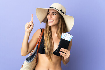 Young caucasian woman holding a passport for holidays isolated on purple background intending to realizes the solution while lifting a finger up