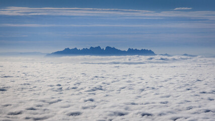 Montserrat mountain above a sea of clouds seen from Rasos de Peguera range, in the Pre-Pyrenees (Berguedà, Catalonia, Spain)
