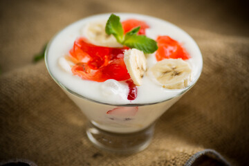 homemade sweet yogurt with bananas and pieces of fruit jelly