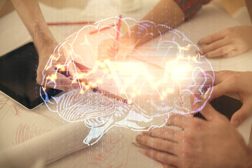 Double exposure of man and woman working together holding and using a mobile device and brain...