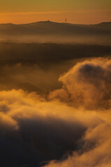 Fototapeta premium Serra de Collserola range over a sea of clouds at sunrise seen from the Creu de Sant Miquel viewpoint in Montserrat (Barcelona province, Catalonia, Spain)
