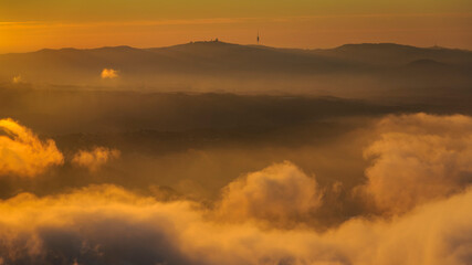 Serra de Collserola range over a sea of clouds at sunrise seen from the Creu de Sant Miquel viewpoint in Montserrat (Barcelona province, Catalonia, Spain)