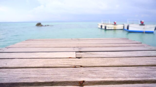 The  wooden bridge stretches out into the calm sea.