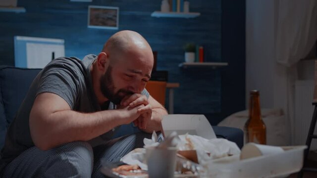 Lonely depressed traumatised man with tears sitting on couch crying feeling exhausted frustrated disappointed stressed vulnerable suffering from anxiety chronic disease bipolar disorder mental problem