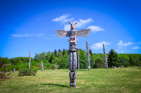 The burial place of First Nations - indigenous people. The view on the sacred totem poles on the green field in Alert Bay, BC.