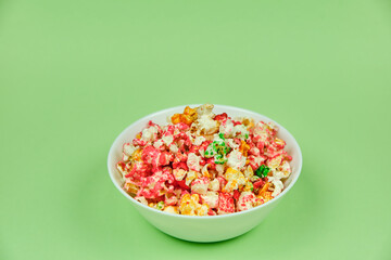 Colorful popcorn on a bowl with a green background