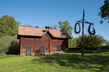 Old falu red wooden barn and a may pole from the 1700s in the countryside of Stockholm