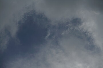Fototapeta na wymiar Blaue Wolken am Himmel eines aufziehenden Gewitters mit unterschiedlichen Grautönen und Farben