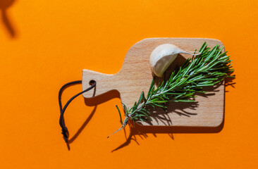 pork chop with cherry tomato and other ingredients such as rosemary, garlic, olive oil. on orange background