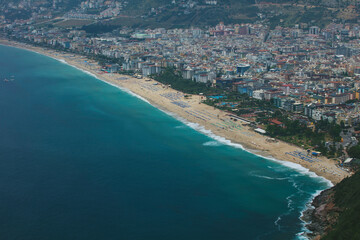 Fototapeta premium Top view of the resort town with houses, hotels and beaches in the mountainous region