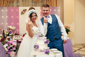 newlyweds are cutting the wedding cake. the inscription on the cake "AK"