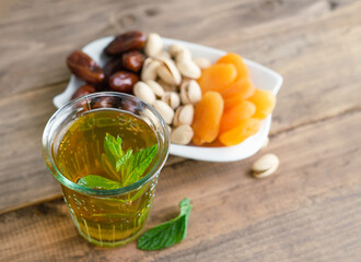 Dried fruit tray with tea glass on wooden background. Copy space.