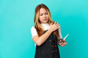 Fototapeta premium Young hairdresser girl over isolated blue background suffering from pain in shoulder for having made an effort