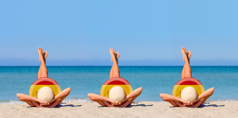 Three young girls sunbathe on the beach wearing straw hats in the colors of the Spanish flag. The concept of a perfect holiday in the resort of Spain. Focus on hats.