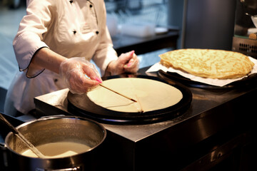 woman prepares pancakes in a cafe. pancake and pancake festival